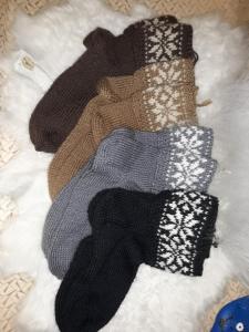 three pairs of socks laying on a blanket at Hænuvík Cottages in Hnjótur