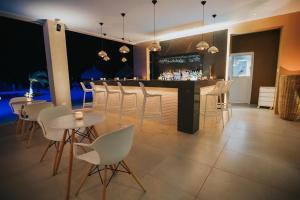 een restaurant met een bar met witte stoelen en tafels bij Gold Coast Home Walk Beach 3 Community Pools in Palm-Eagle Beach