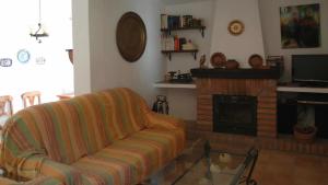 een woonkamer met een bank en een open haard bij Granada 003 in Alhama de Granada