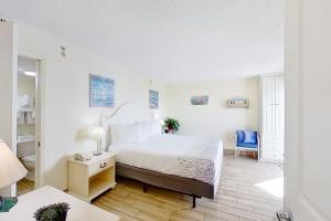 a white bedroom with a bed and a desk at Bay Watch 1941 in Myrtle Beach +22 photos