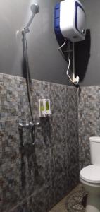 um chuveiro na casa de banho com WC em Rock and Wreck Dive Resort em Tanjungbinga