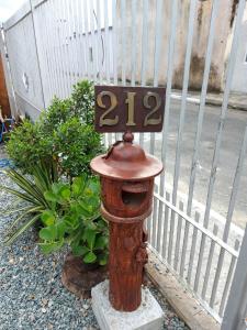 a fire hydrant sitting in front of a fence at Quarto em Itajaí SC com banheiro e cozinha privativo estilo loft in Itajaí