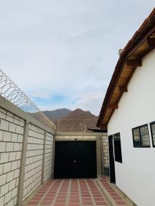 a garage with a black door and mountains in the background at Casa campestre los cerezos in Santa Marta