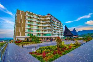 a large building with a garden in front of it at Labersa Hotel & Convention Center Toba Balige in Balige