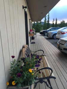 a wooden bench with flowers on it near a dock at Denali Park Hotel in Healy