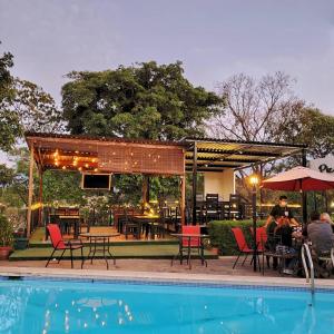 a group of people sitting at a table by a pool at VILLA NAPOLI in Santa Ana