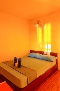 a bedroom with a large bed with yellow walls at J.B.Hut Bungalows in Haad Yao