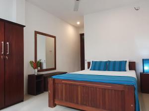 a bedroom with a large bed and a mirror at Lohas Beach Resort Villa in Kalutara