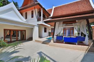 a house with a patio with blue chairs on it at Siam Pool Villa Pattaya in Pattaya South