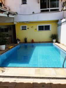 Una gran piscina con agua azul frente a un edificio. en Aconchego e requinte flat Praia atalaia, en Aracaju