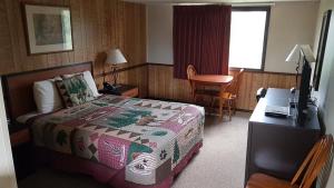 a hotel room with a bed and a desk with a television at Denali Park Hotel in Healy +25 photos