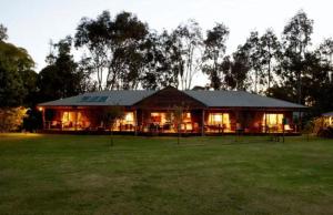 a large building with lights on in a field at Lazy River Boutique Bed & Breakfast in Pinjarra