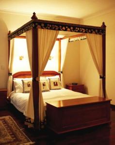een slaapkamer met een hemelbed en een baldakijn bij Lazy River Boutique Bed & Breakfast in Pinjarra