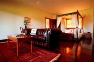 een woonkamer met een bank en een tafel bij Lazy River Boutique Bed & Breakfast in Pinjarra