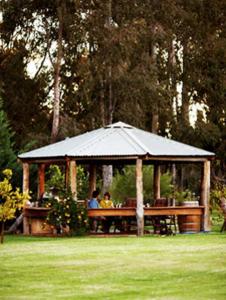 
a picnic table in a grassy area with trees at Lazy River Boutique Bed & Breakfast in Pinjarra

