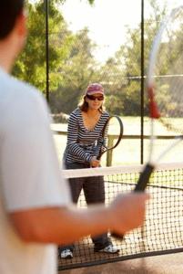 
a man holding a tennis racquet on a tennis court at Lazy River Boutique Bed & Breakfast in Pinjarra
