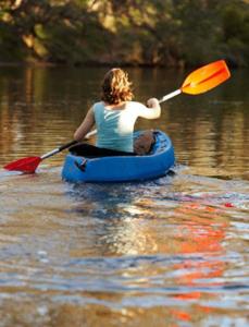 a woman in a blue kayak on a lake at Lazy River Boutique Bed & Breakfast in Pinjarra