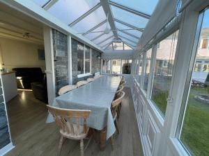 einen Wintergarten mit einem Tisch, Stühlen und einem Glasdach in der Unterkunft Ivy Tower Cottages in Saint Florence