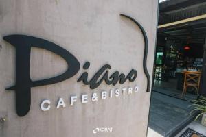 una señal para una cafetería y un restaurante al lado de un edificio en The Piano Resort Khaoyai, en Mu Si