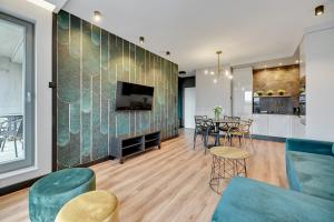 a living room with a couch and a tv and a table at Grano Residence - Pool, Sauna, SPA & Parking by Downtown Apartments in Gdańsk