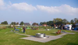 a park with people walking around in a field at de Bülk in Dorum Neufeld