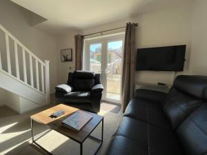ein Wohnzimmer mit einem Sofa und einem Stuhl in der Unterkunft Gorsebank View in Inverness