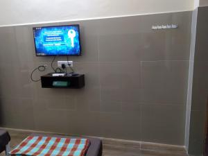 uma televisão de ecrã plano numa parede num quarto em TKK Residency em Vellore