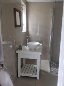 izuba lodge في كيب تاون: حمام أبيض مع حوض ودش