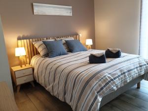 a bedroom with a large bed with blue pillows at Le Temps d'une Pause in Bretignolles-sur-Mer
