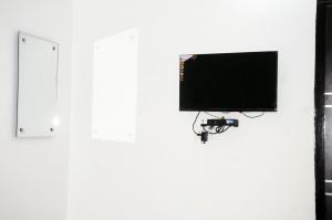 a flat screen tv on a wall with a camera at Ishaan Hotel in Gangānagar