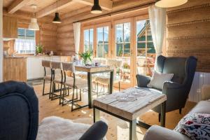 a living room with a table and chairs and a kitchen at Nydala Rustic in Kościelisko