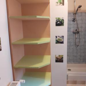 a bathroom with yellow shelves and a shower at Les deux arches in Caunes-Minervois