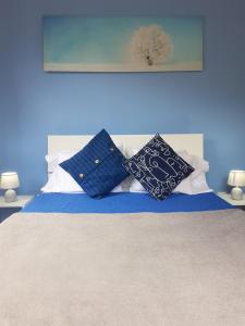 a bed with two blue and white pillows on it at FX Carvalhal in Funchal