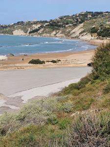 una playa vacía con gente caminando por la arena en Casa del re en Licata