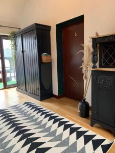 a room with a black and white rug and a door at Malswick Mill in Newent