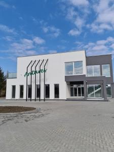 een groot wit gebouw met een bord erop bij Hotel ANTARES in Sępólno Krajeńskie