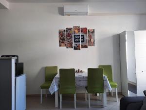 a dining room with a table and green chairs at Apartment GS CENTAR in Gospić