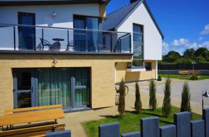 a house with a bench in front of it at Smėlio Vila Apartments in Palanga