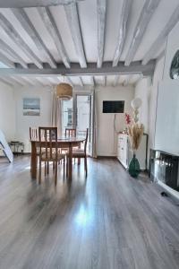 een woonkamer met een houten tafel en stoelen bij LE KALEHO, Grand Duplex au coeur de Dieppe - NETFLIX in Dieppe