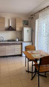 a kitchen with a table and a kitchen with a refrigerator at Mini-Otel Luch in Odesa