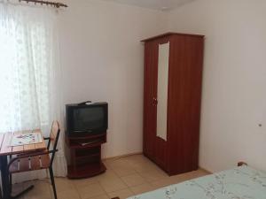a room with a tv and a wooden cabinet at Mini-Hotel Luch in Odesa