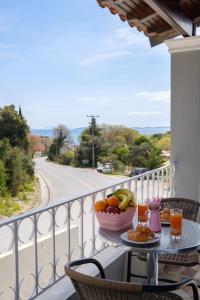 a table with a bowl of fruit on a balcony at Pyrgi House 150m from Ipsos Beach with Sea View in Ipsos +18 photos