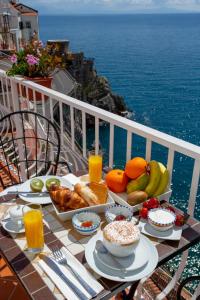 アマルフィにあるドンナ ジュリアの海を見渡すバルコニーにテーブルと朝食用の食材を用意しています。