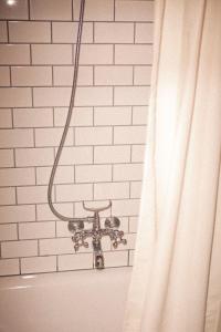 La salle de bains est pourvue d'un rideau de douche à côté d'un mur en briques blanches. dans l'établissement Kex Hostel, à Reykjavik