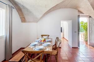 a dining room with a wooden table and chairs at Son Camaro in Ciutadella