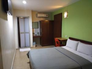 a bedroom with a bed and a desk with a television at U HOTEL in Skudai