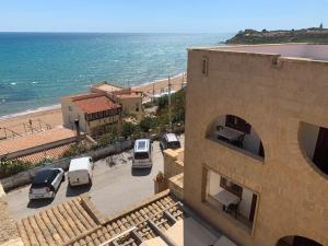 um edifício com vista para a praia e para o oceano em La Rosa Hotel - Selinunte em Marinella di Selinunte