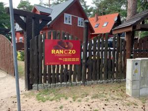 a sign on a wooden fence in front of a house at Ranczo Pobierowo in Pobierowo