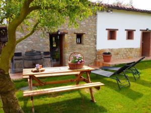 una mesa de picnic en un patio junto a una casa en El llagar - Sagasta Rural Oviedo, en Oviedo