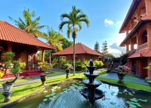a fountain in the middle of a courtyard with buildings at Gayatri in Ubud
